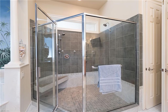 bathroom featuring a shower with shower door, ornate columns, and tile patterned flooring