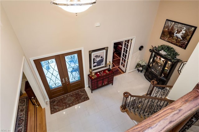 tiled foyer entrance featuring french doors and a high ceiling