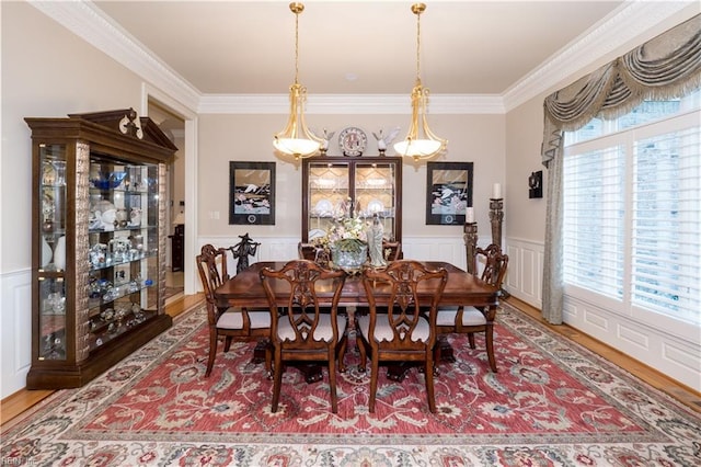 dining space with ornamental molding and hardwood / wood-style flooring