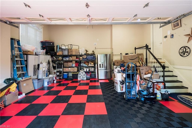 garage featuring stainless steel refrigerator with ice dispenser