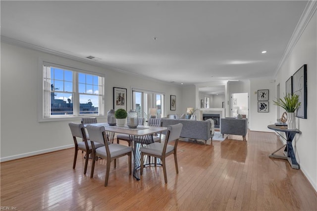 dining room with crown molding and light wood-type flooring