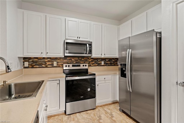 kitchen with stainless steel appliances, white cabinets, and sink