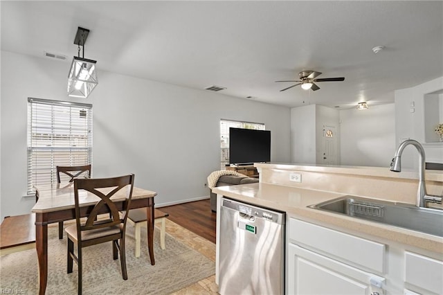 kitchen with dishwasher, decorative light fixtures, white cabinetry, ceiling fan, and sink