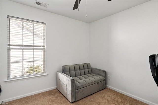 sitting room with ceiling fan and light carpet