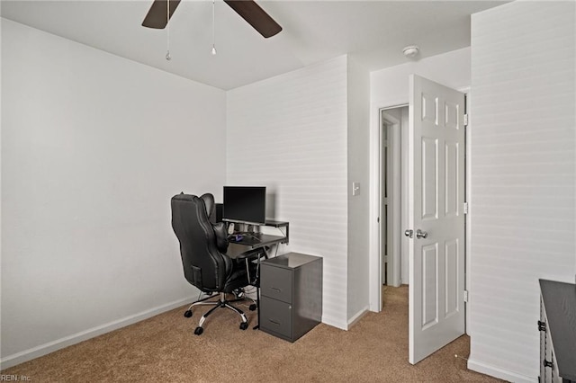 carpeted home office featuring ceiling fan