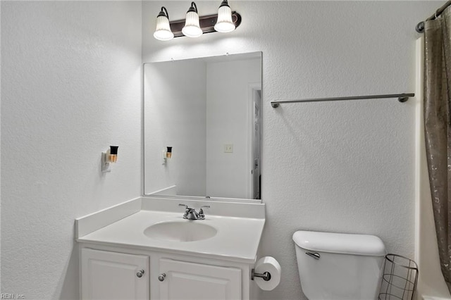 bathroom with toilet, a shower with curtain, and vanity