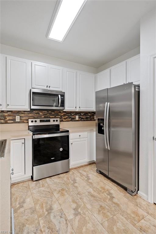 kitchen featuring appliances with stainless steel finishes, white cabinetry, and decorative backsplash