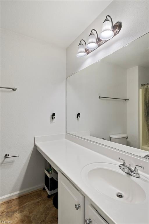 bathroom with toilet, a shower with shower curtain, and vanity