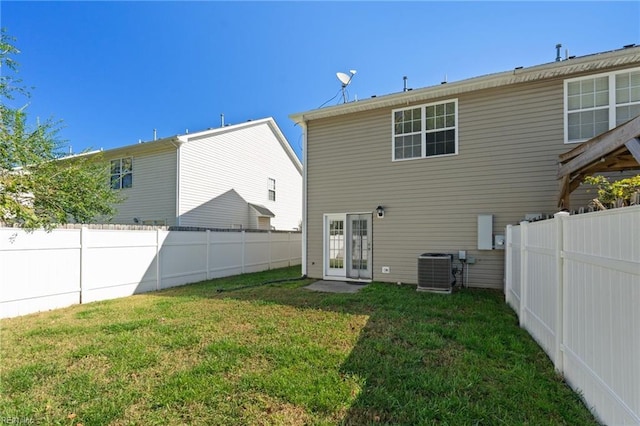 back of property with cooling unit and a yard