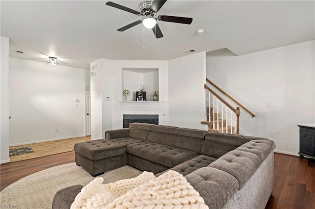 living room featuring ceiling fan and dark hardwood / wood-style floors