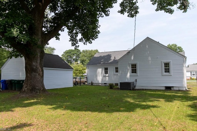 back of property featuring a lawn and central AC