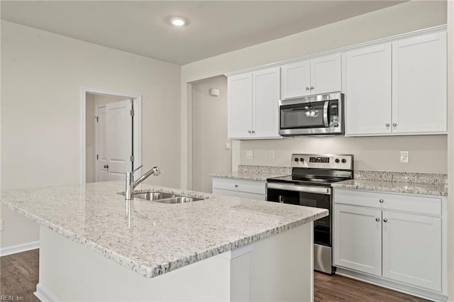 kitchen with dark hardwood / wood-style floors, an island with sink, sink, white cabinetry, and appliances with stainless steel finishes