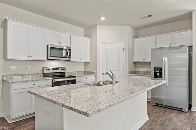 kitchen with a center island with sink, white cabinetry, wood-type flooring, sink, and stainless steel appliances