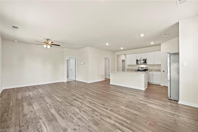 unfurnished living room with ceiling fan and light wood-type flooring