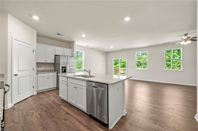 kitchen with a kitchen island with sink, appliances with stainless steel finishes, dark wood-type flooring, and white cabinets