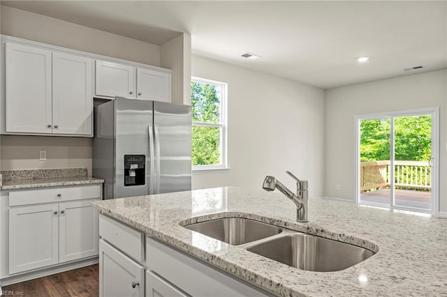 kitchen featuring white cabinetry, stainless steel refrigerator with ice dispenser, and plenty of natural light