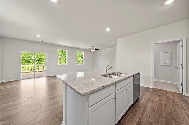 kitchen featuring stainless steel dishwasher, sink, wood-type flooring, and an island with sink