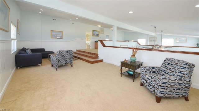 living area with vaulted ceiling, a wealth of natural light, and light colored carpet