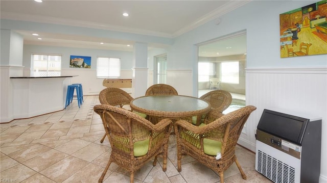 tiled dining space featuring ornamental molding and heating unit