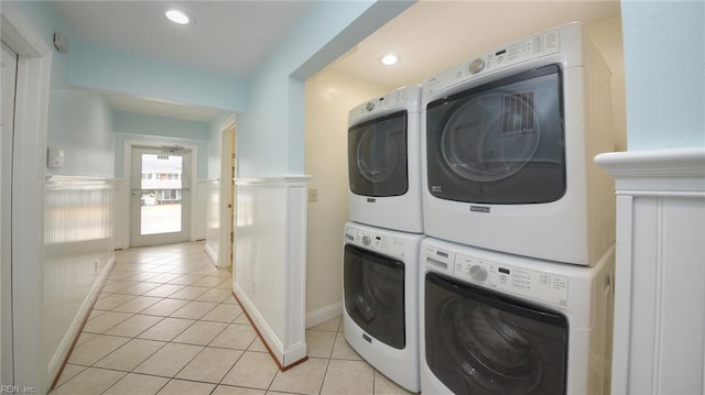 laundry room featuring stacked washer / drying machine and light tile patterned floors