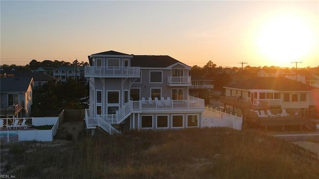 back house at dusk featuring a balcony