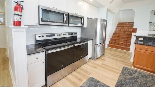 kitchen with white cabinetry, stainless steel appliances, and light hardwood / wood-style floors