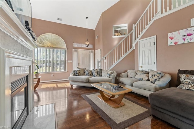 living room featuring high vaulted ceiling and dark hardwood / wood-style flooring