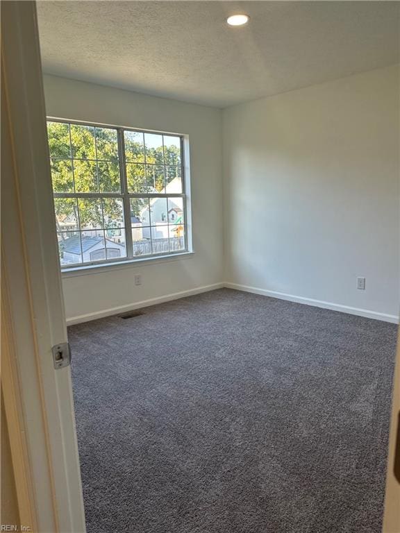 spare room featuring dark carpet