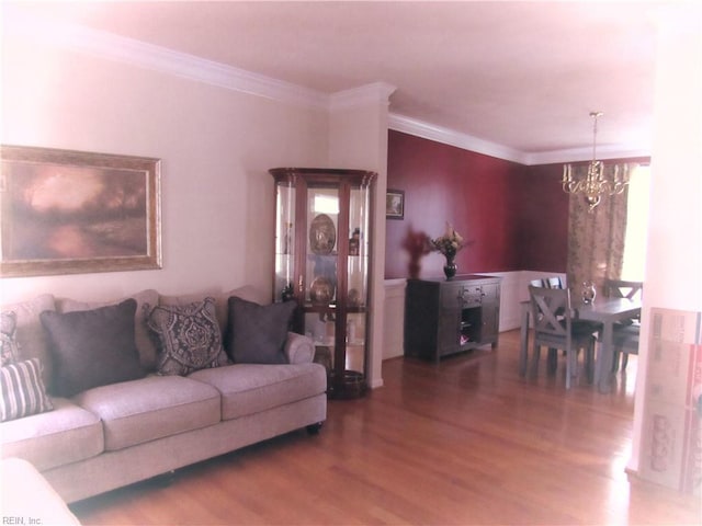 living room featuring hardwood / wood-style flooring, crown molding, and a notable chandelier