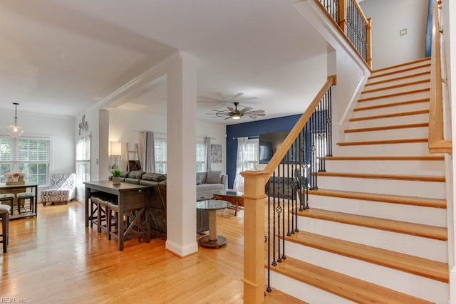 stairway with wood-type flooring and ceiling fan