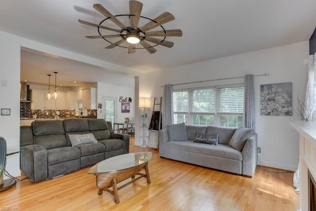 living room with light hardwood / wood-style floors and ceiling fan