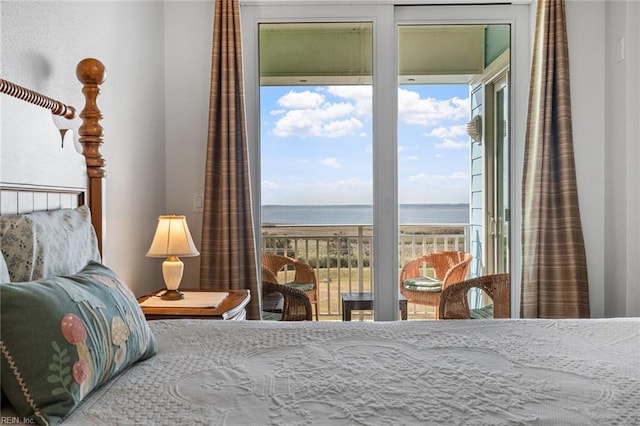 bedroom with a water view, multiple windows, and access to exterior