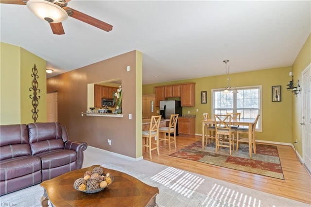 living room featuring light wood-type flooring and ceiling fan