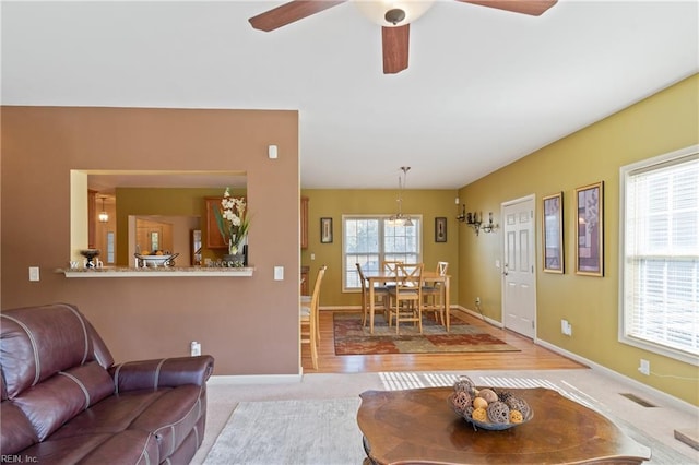 living room with a wealth of natural light, light wood-type flooring, and ceiling fan