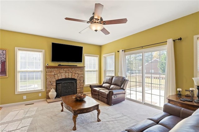 carpeted living room featuring a healthy amount of sunlight, a fireplace, and ceiling fan