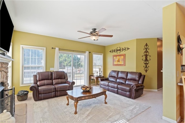 living room with light colored carpet, a fireplace, and ceiling fan