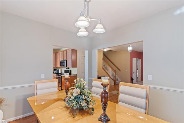 dining room with light hardwood / wood-style floors and an inviting chandelier