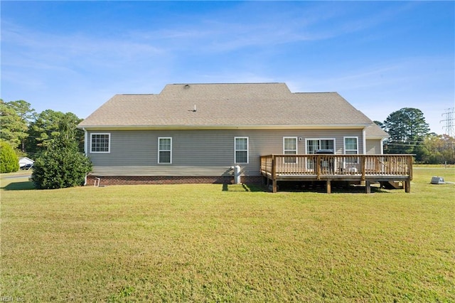 rear view of property featuring a yard and a deck