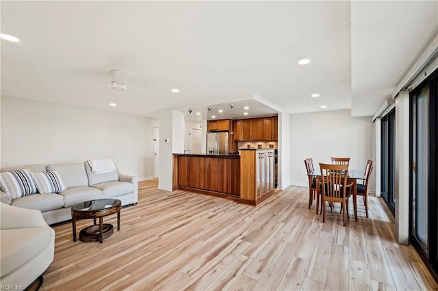 living room with light hardwood / wood-style flooring and ceiling fan