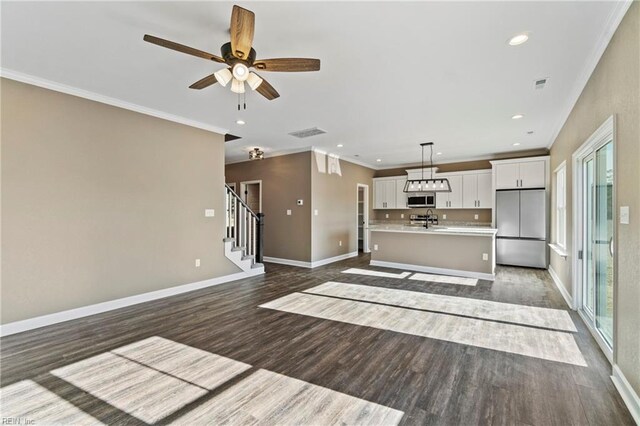 unfurnished living room with ornamental molding, dark hardwood / wood-style floors, and ceiling fan