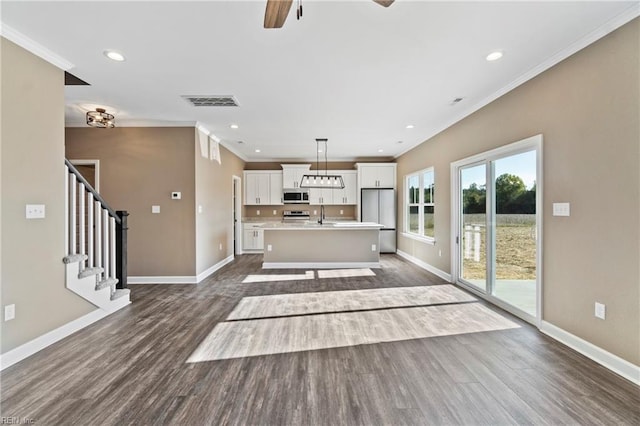 unfurnished living room with crown molding, sink, dark wood-type flooring, and ceiling fan