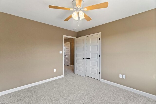 unfurnished bedroom featuring light carpet, a closet, and ceiling fan