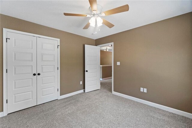 unfurnished bedroom with light colored carpet, a closet, and ceiling fan