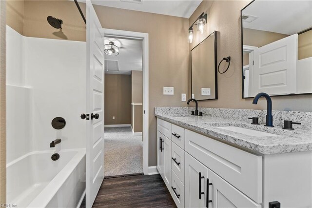 bathroom featuring  shower combination, vanity, and hardwood / wood-style floors