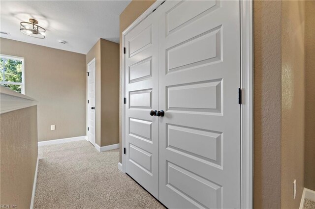 hallway with light colored carpet