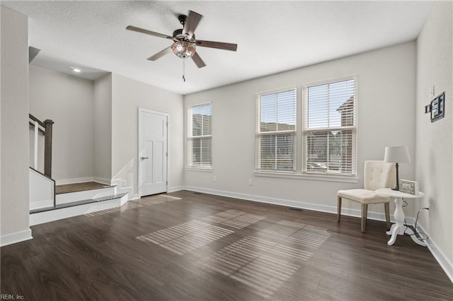 interior space featuring ceiling fan, a textured ceiling, and dark hardwood / wood-style flooring