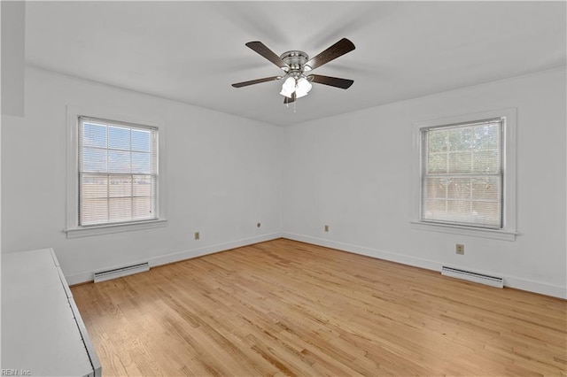 spare room featuring a baseboard radiator, light wood-type flooring, and ceiling fan