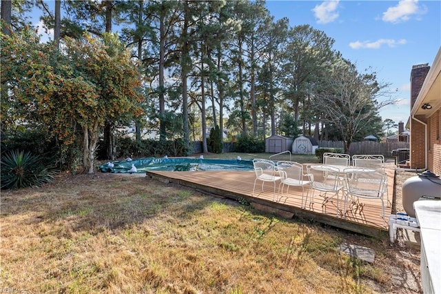 view of yard featuring a swimming pool side deck and a storage shed