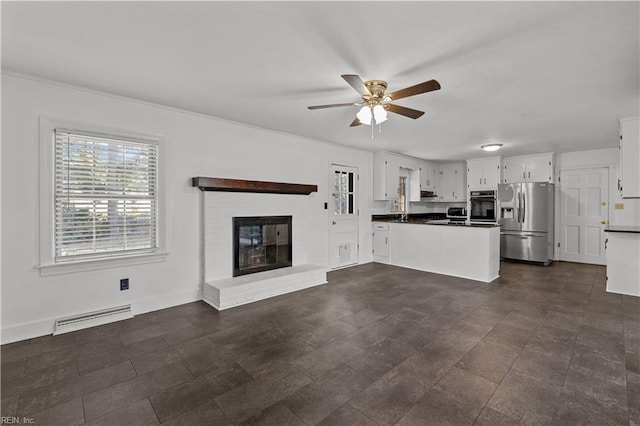 unfurnished living room with ceiling fan and a brick fireplace