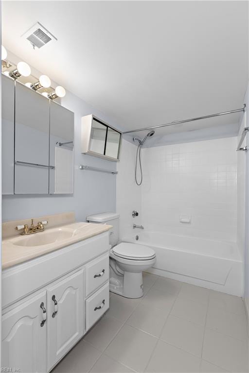 full bathroom featuring vanity, tiled shower / bath, tile patterned floors, and toilet